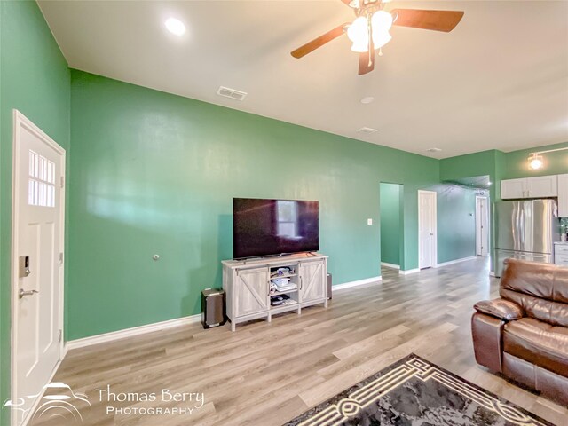 living room with ceiling fan and light hardwood / wood-style flooring