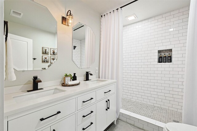 bathroom with vanity, curtained shower, tile patterned floors, and toilet