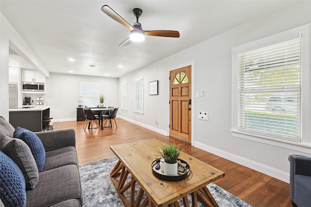 living room with a wealth of natural light, ceiling fan, and light hardwood / wood-style floors