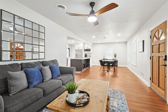 living room featuring hardwood / wood-style floors and ceiling fan