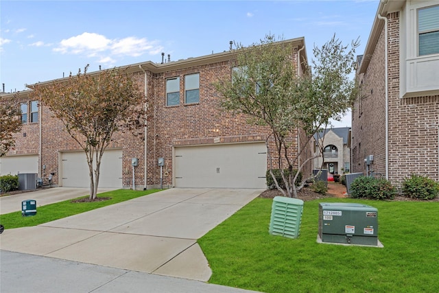 view of front of property with cooling unit, a garage, and a front yard