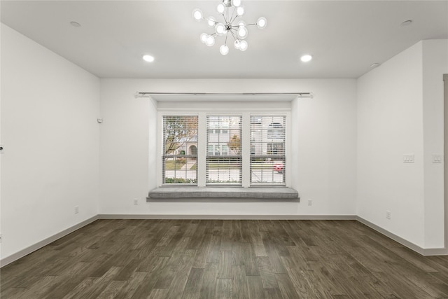 unfurnished room featuring dark hardwood / wood-style floors and a notable chandelier