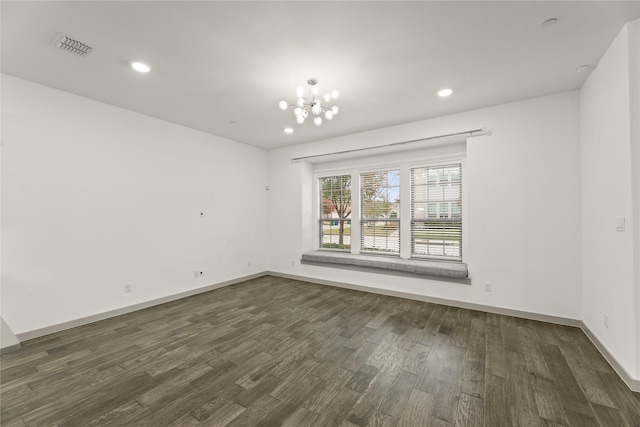 unfurnished room with dark wood-type flooring and an inviting chandelier