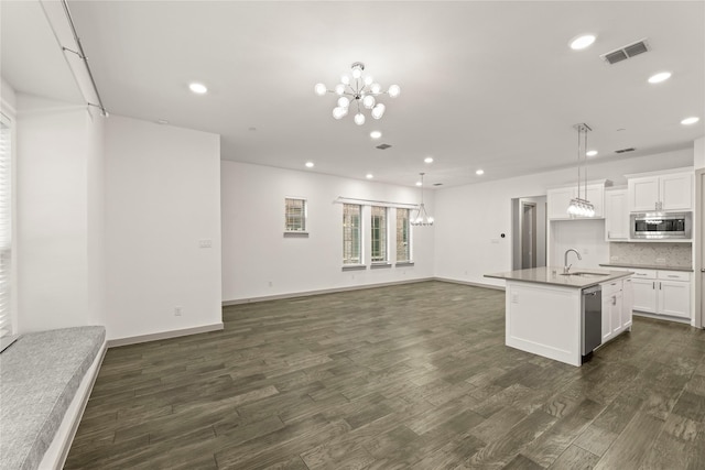 kitchen with appliances with stainless steel finishes, dark hardwood / wood-style flooring, sink, a center island with sink, and white cabinetry