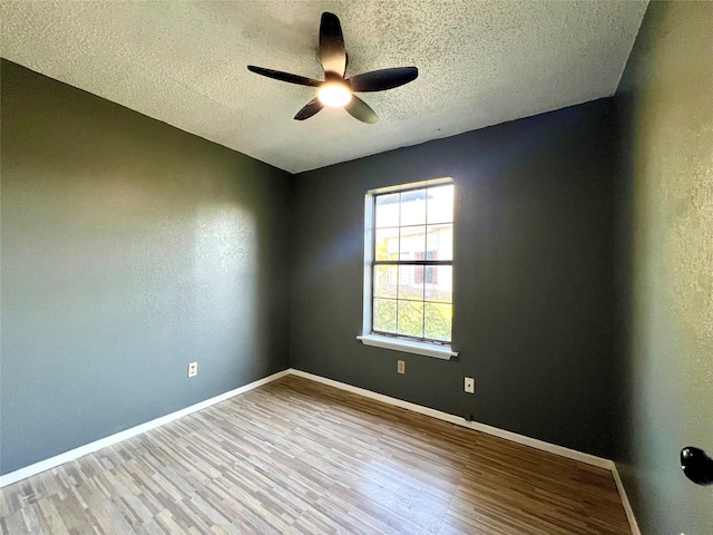 spare room with ceiling fan, a textured ceiling, and light hardwood / wood-style flooring