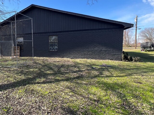 view of side of home with a yard