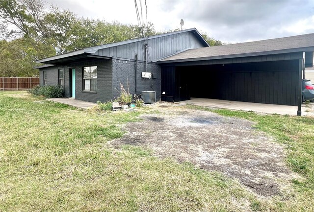 view of side of home featuring a yard, central AC unit, and a carport