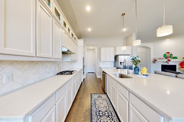 kitchen featuring a kitchen island with sink, hardwood / wood-style floors, stainless steel appliances, and decorative light fixtures