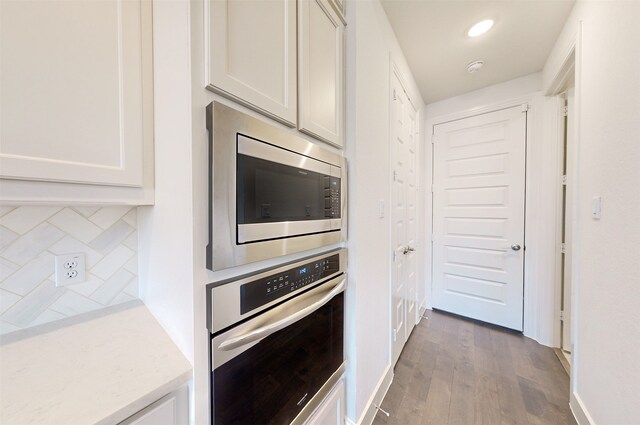 kitchen with a center island with sink, pendant lighting, white cabinets, and stainless steel appliances