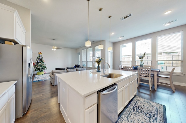 kitchen with a kitchen island with sink, sink, dark hardwood / wood-style flooring, white cabinetry, and stainless steel appliances