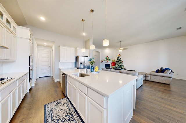 kitchen with white cabinetry, sink, dark wood-type flooring, stainless steel appliances, and an island with sink