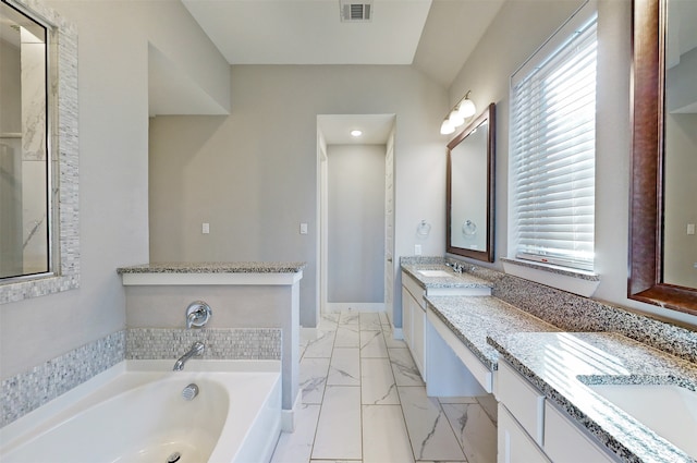 bathroom with a tub and vanity