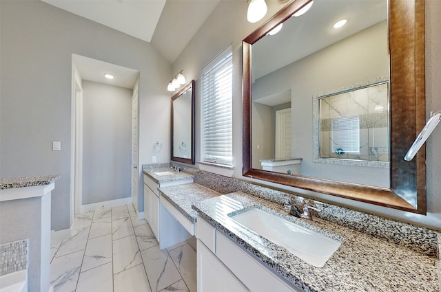 bathroom featuring a shower with door, vanity, and vaulted ceiling