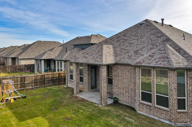 rear view of property with a yard and a patio