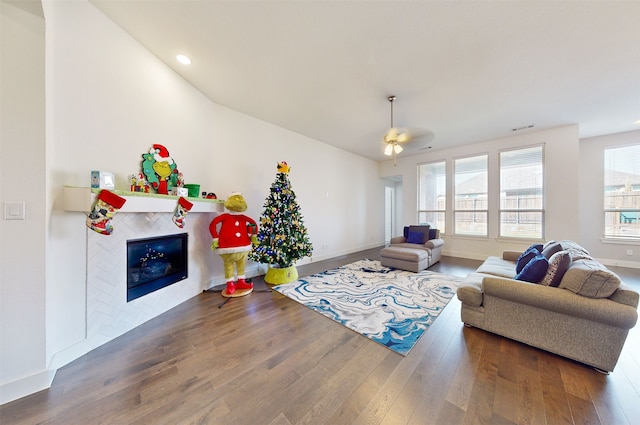 living room with a tile fireplace, hardwood / wood-style floors, and ceiling fan