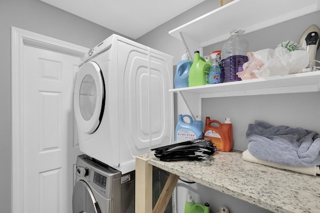 clothes washing area featuring stacked washer and clothes dryer