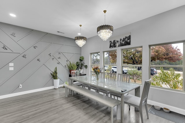 dining area featuring a notable chandelier, plenty of natural light, and hardwood / wood-style flooring