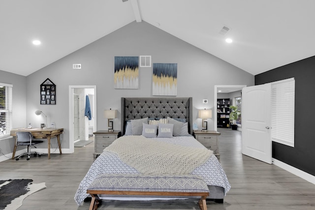 bedroom featuring ensuite bathroom, high vaulted ceiling, and hardwood / wood-style flooring