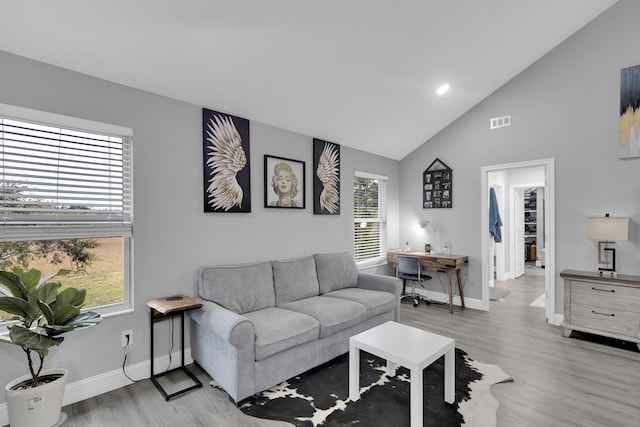 living room featuring high vaulted ceiling and light wood-type flooring