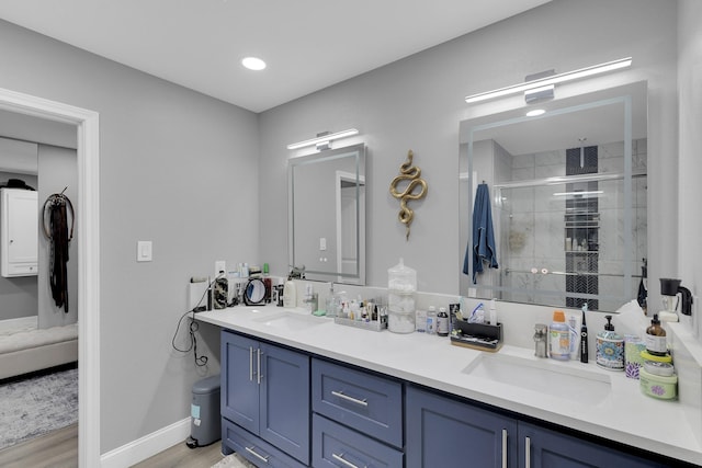 bathroom with vanity, hardwood / wood-style flooring, and a shower with shower door