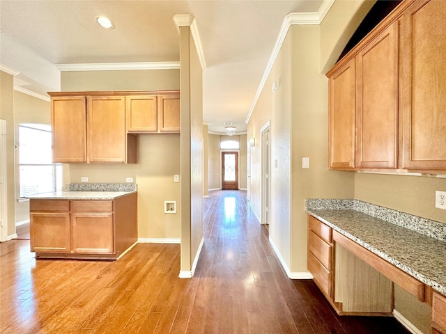 kitchen with light hardwood / wood-style floors, light stone counters, and crown molding