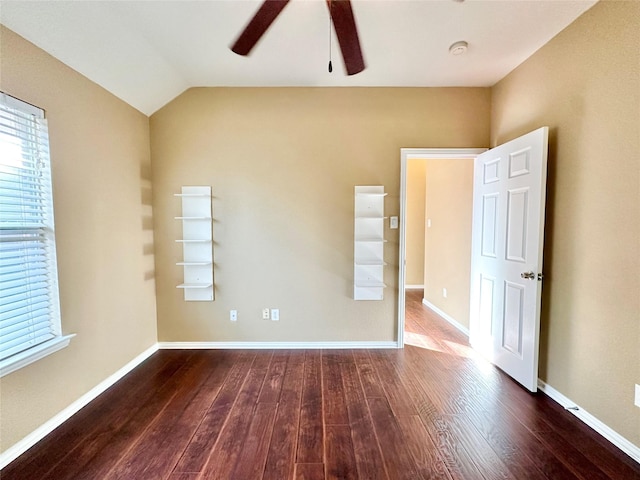 empty room with ceiling fan, dark wood-type flooring, and vaulted ceiling