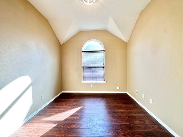 spare room with dark hardwood / wood-style floors and lofted ceiling