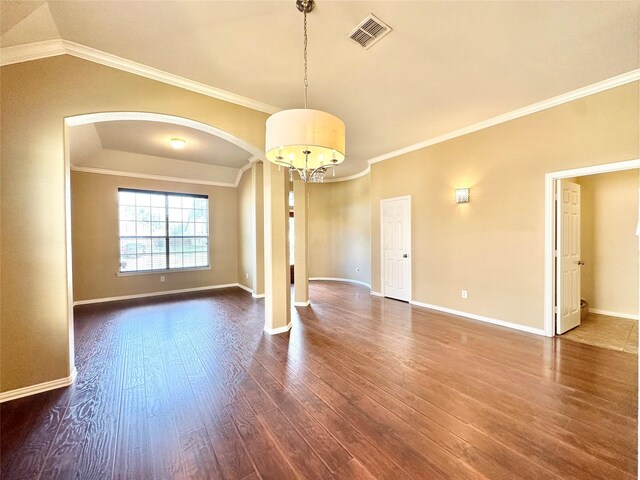 unfurnished room with an inviting chandelier, dark wood-type flooring, vaulted ceiling, and ornamental molding