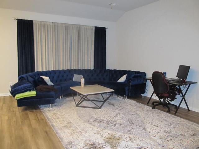 living room with hardwood / wood-style flooring and vaulted ceiling