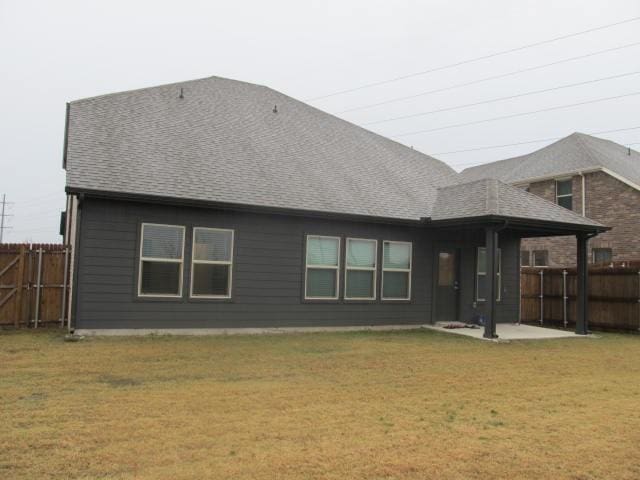 back of property featuring a lawn and a patio