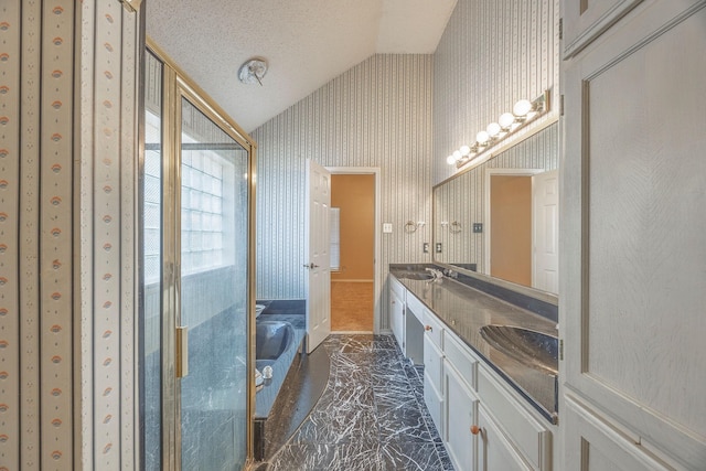 bathroom with a textured ceiling, vanity, and lofted ceiling