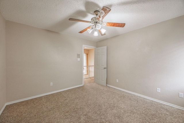 empty room with ceiling fan, carpet floors, and a textured ceiling