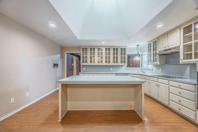 kitchen with cream cabinets, a center island, pendant lighting, and light hardwood / wood-style flooring