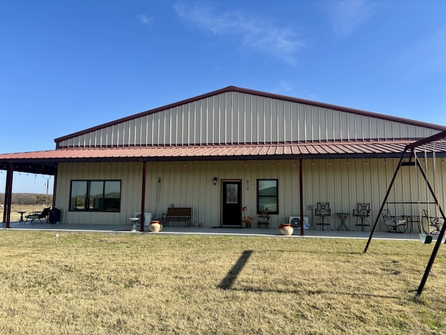 rear view of property featuring a lawn