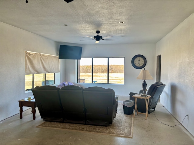 living room with ceiling fan, concrete flooring, and a textured ceiling