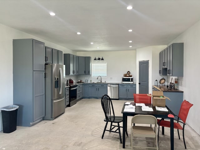 kitchen with gray cabinetry, sink, and stainless steel appliances