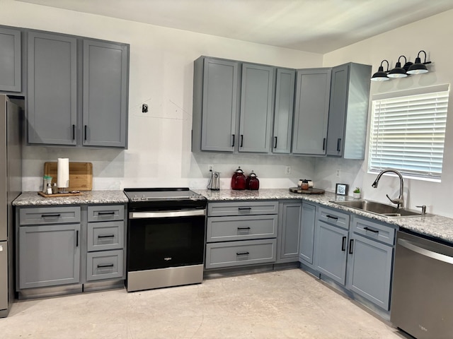 kitchen featuring gray cabinetry, light stone counters, sink, and stainless steel appliances