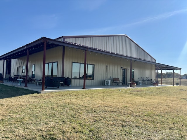 view of side of property featuring a patio and a lawn