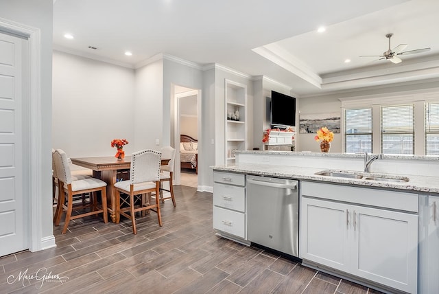 kitchen with dishwasher, sink, ceiling fan, light stone countertops, and dark hardwood / wood-style flooring