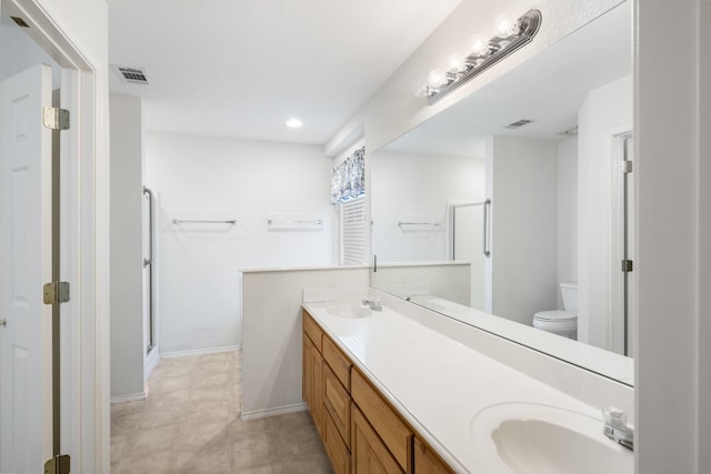 bathroom with vanity, toilet, and a shower with shower door