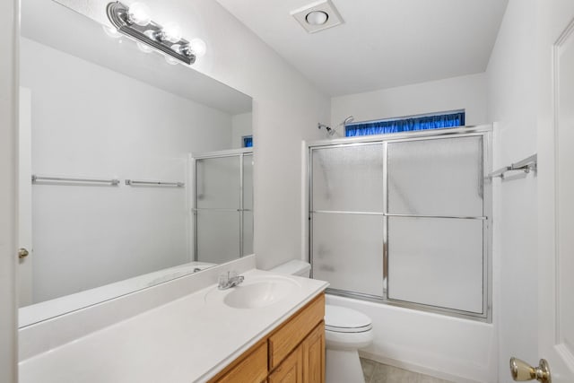 full bathroom featuring tile patterned flooring, vanity, bath / shower combo with glass door, and toilet