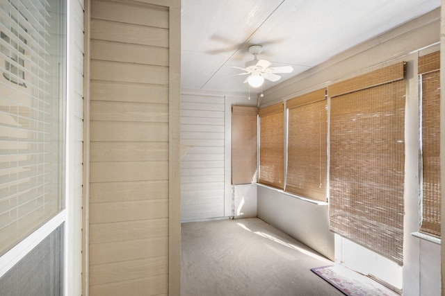 unfurnished sunroom with ceiling fan