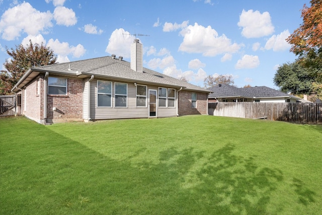 rear view of house with a yard