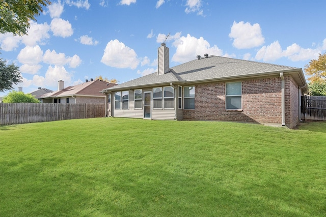 rear view of property with a lawn