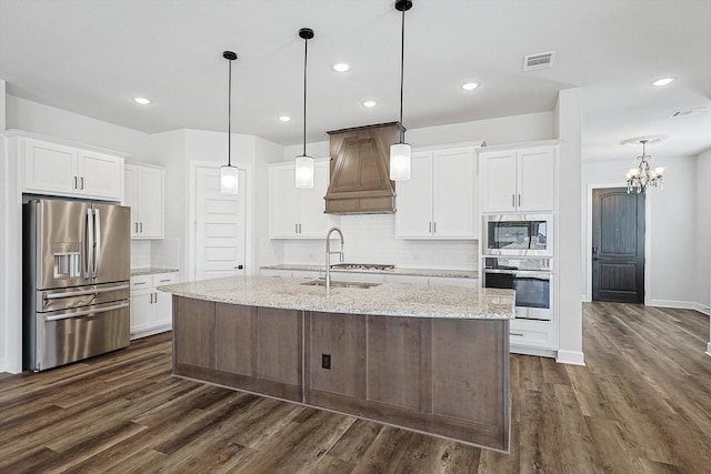 kitchen featuring light stone countertops, an island with sink, appliances with stainless steel finishes, and white cabinets