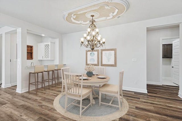 dining room with dark hardwood / wood-style floors and an inviting chandelier