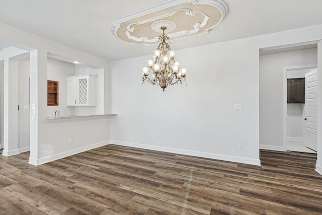 unfurnished dining area featuring an inviting chandelier and dark hardwood / wood-style flooring