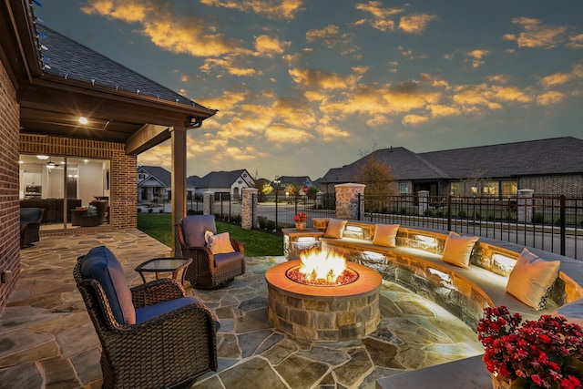 patio terrace at dusk featuring an outdoor living space with a fire pit