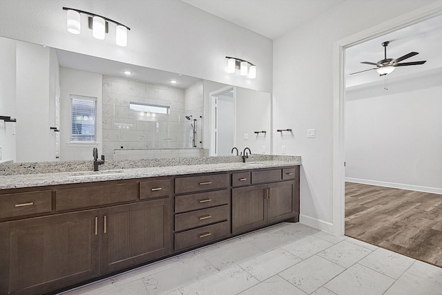 bathroom featuring vanity, a tile shower, and ceiling fan