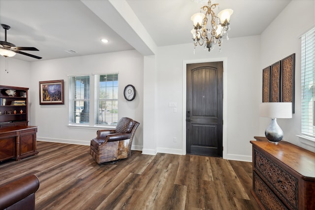 foyer entrance featuring ceiling fan with notable chandelier, dark hardwood / wood-style flooring, and a wealth of natural light